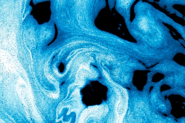 Swirls of foam on blue liquid