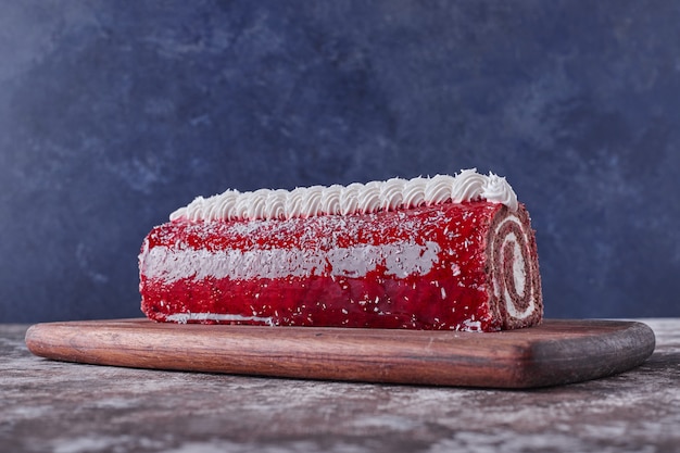 Free photo swiss roll cake with red jelly and white cream