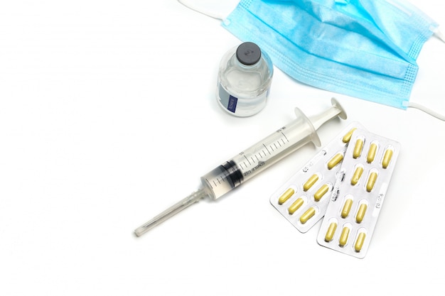 Syringe, capsules,and  medical mask bottle on white background