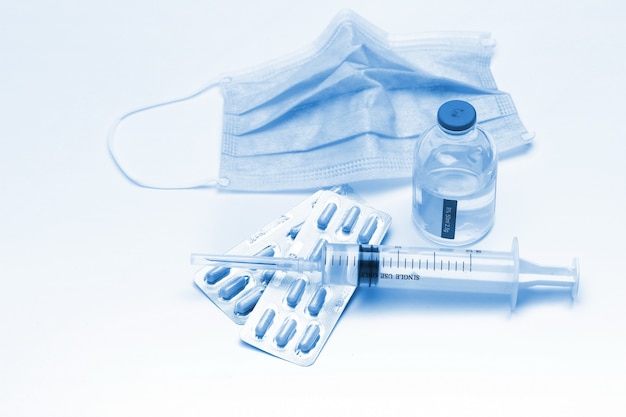 Syringe, capsules,and  medical mask bottle on white background