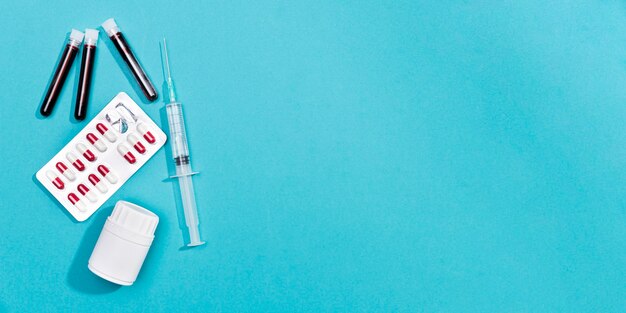 Syringe and pills on table