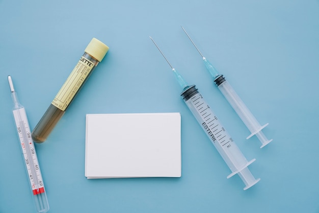 Syringes, thermometer and sample with business card