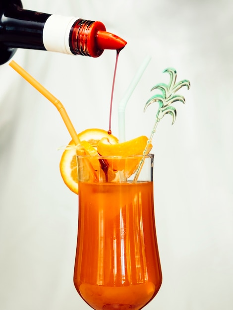 Syrup pouring into tropical cocktail