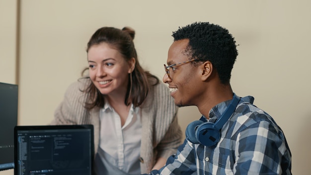 Free photo system engineers celebrating successful code compiling doing high five hand gesture with colleague. coder analyzing algorithm on multiple screens takes off glasses and congratulates coworker.