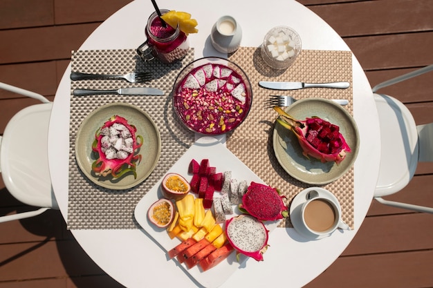 Free photo table arrangement with dragon fruit snacks outdoors