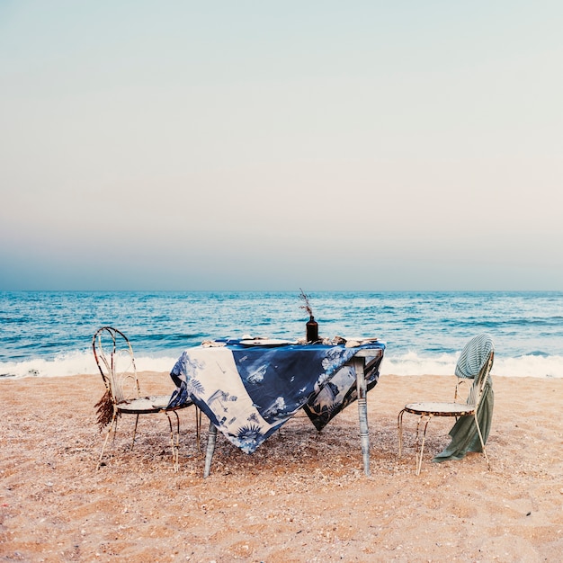 Free photo table chairs meal sea shore holiday sky concept