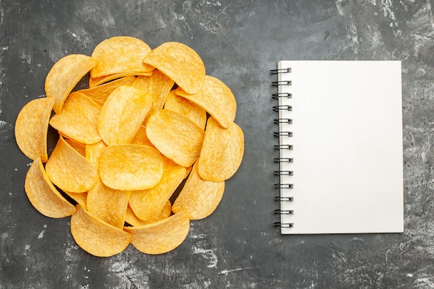 Free Photo table decoration with homemade potato chips on notebook on gray background