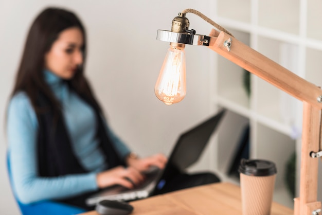 Free Photo table lamp near working woman