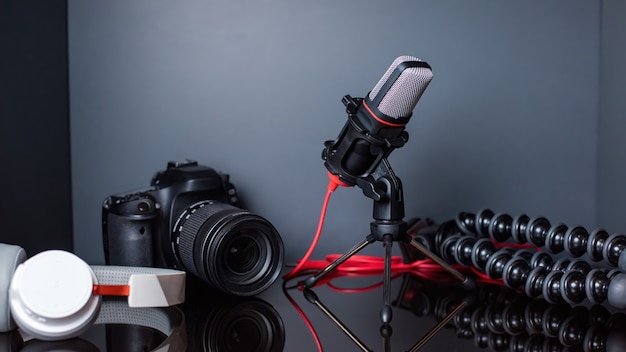 Free photo table with content creator stuff. camera, microphone, tripod and headphones. working from home