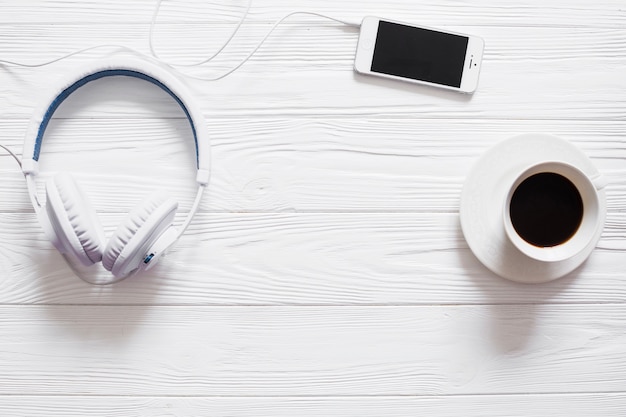 Table with headphones, coffee and phone