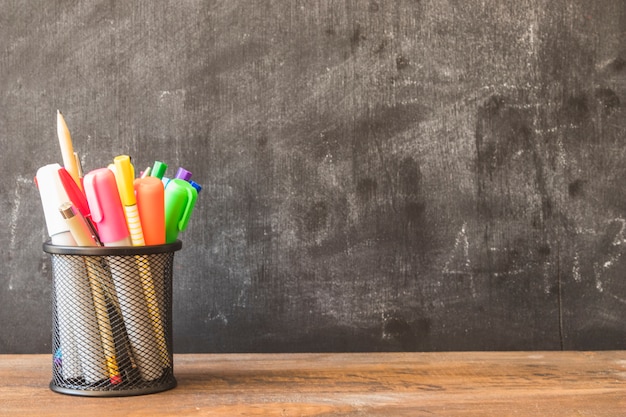 Free Photo table with pencil cup near blackboard