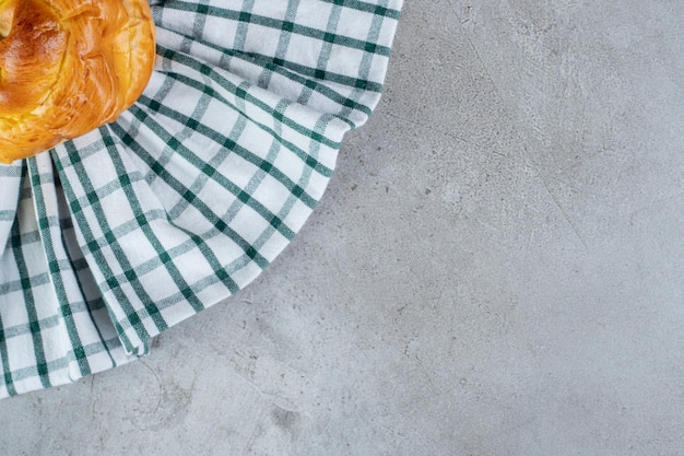 Free photo tablecloth under a sweet bun on marble