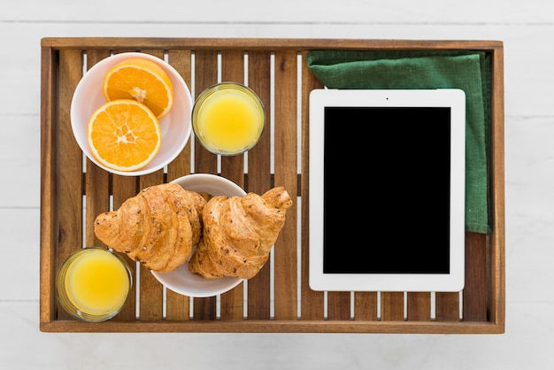 Free photo tablet near food on breakfast table