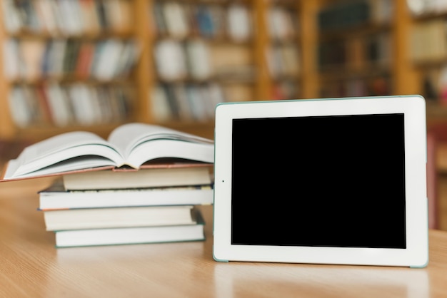 Tablet near pile of books