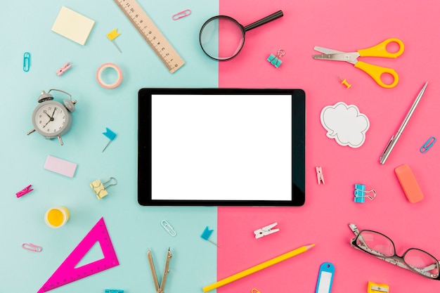 Free photo tablet surrounded by stationery supplies on the table