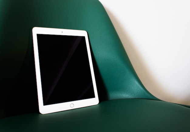 Free photo tablet with blank screen on a chair