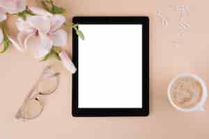 Free photo tablet with coffee cup and flowers