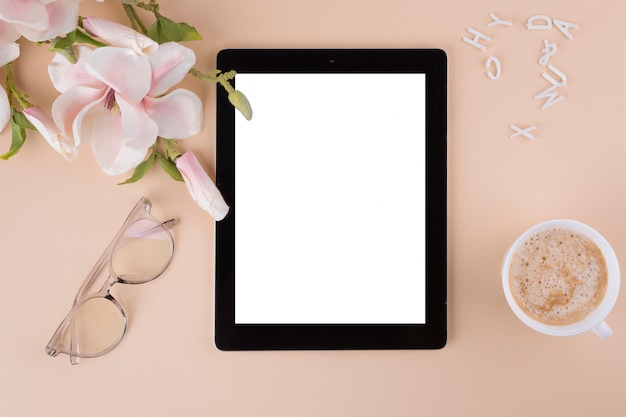 Tablet with coffee cup and flowers 