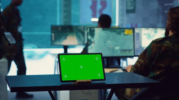 Free Photo tablet with greenscreen display running in a command post base of operations