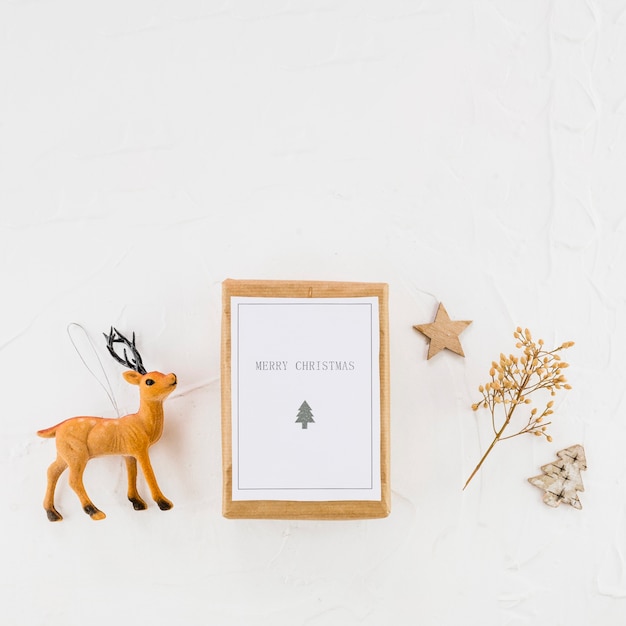 Free photo tablet with paper between decorative fir tree, star and toy deer