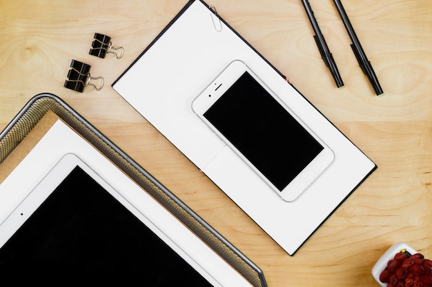 Tablet with smartphone on wooden table 