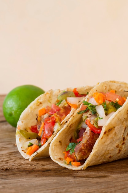 Tacos and lime on wooden table