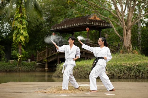 Free photo taekwondo training taking place outdoors in nature with two people