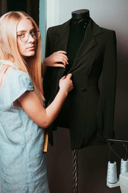 Free Photo tailor touching jacket on mannequin 