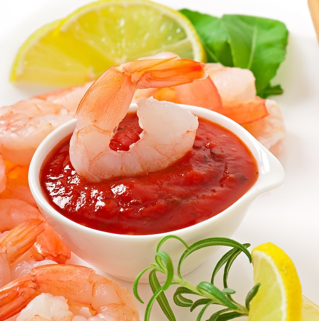 tails of shrimps with fresh lemon and rosemary in a white bowl