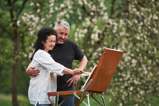 Take a look at this. Mature couple have leisure days and working on the paint together in the park