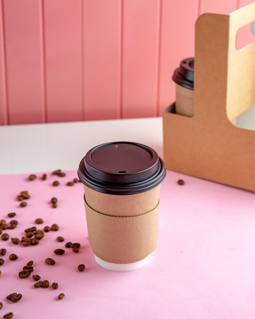 takeaway coffee with coffee beans on table