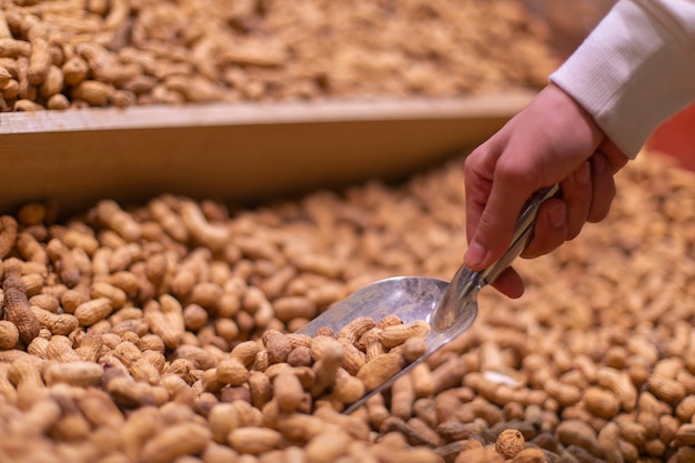 Free photo taking peanuts from the stock at the grocery. high quality photo