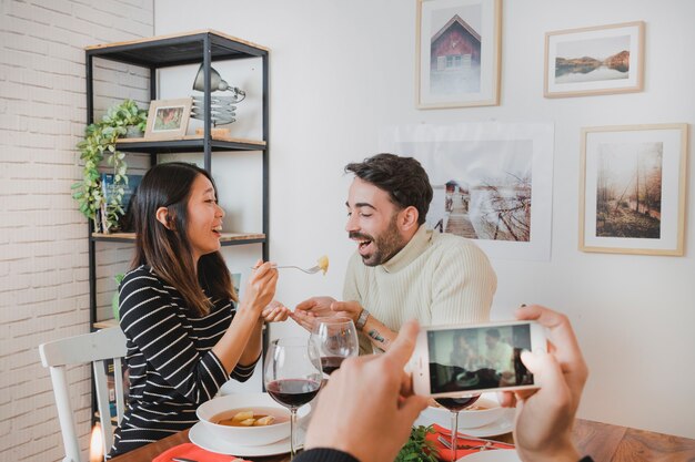 Taking photo of happy couple at christmas dinner