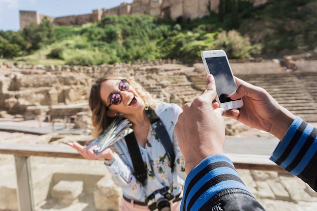 Taking photo of laughing girlfriend in front of monument