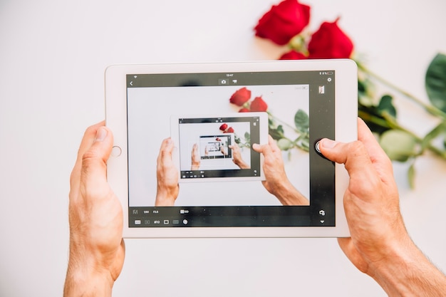 Free photo taking photo of roses with tablet