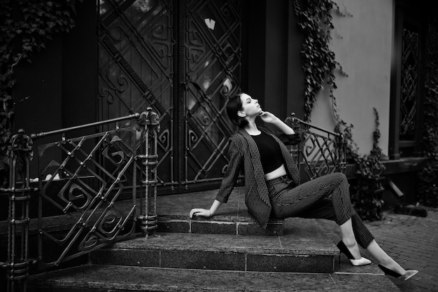 Free Photo a tall leggy young beautiful and elegant model woman at formal wear posed on stairs