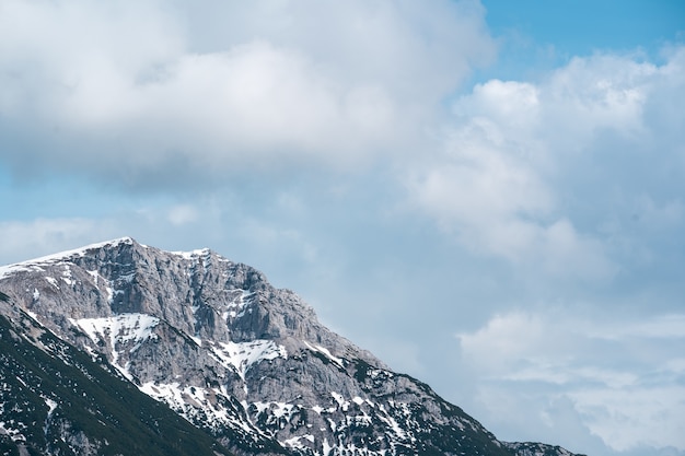 Tall rocky mountain under the cloudy sky