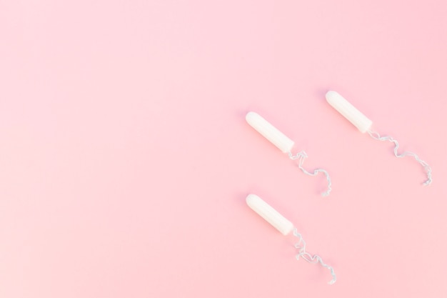 Tampons with thread and copy space pink background