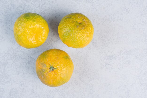 Tangerines (oranges, clementines, citrus fruits) over grey background . 