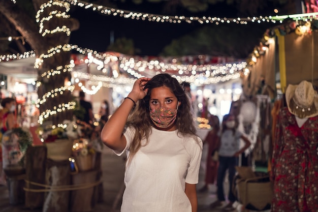 Tanned Caucasian female wearing a floral mask at an amusement park