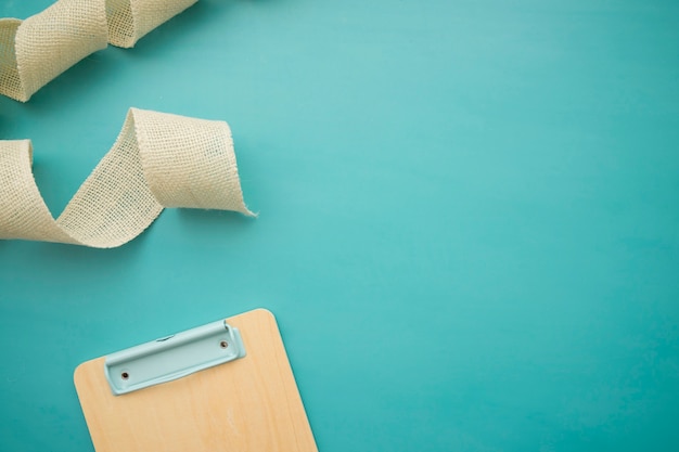 Tape and clipboard on blue background