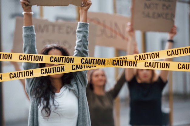 Free photo tape covering girl's eyes. group of feminist women have protest for their rights outdoors