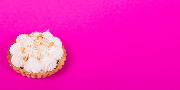 Tartlet with italian meringue against pink background