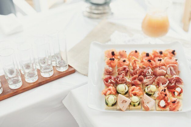 Tasty appetizers of fish and vegetables served on square plate