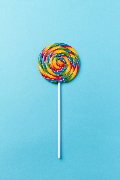 Tasty appetizing Party Accessory Sweet Swirl Candy Lollypop on Blue Background Top View