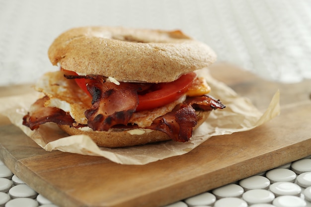 Tasty bagel sandwich with bacon