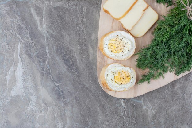 Free photo tasty boiled eggs on white breads with greens on wooden board. high quality photo