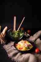 Free photo tasty boiled spaghetti pasta with basil leaves and tomato on sack with bread sticks and veg salad