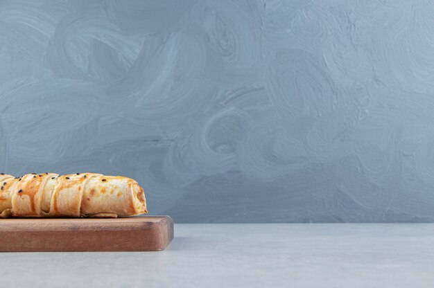 Tasty braided bun on wooden board. 