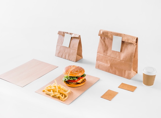 Free Photo tasty burger; french fries; parcels and disposal cup on white surface